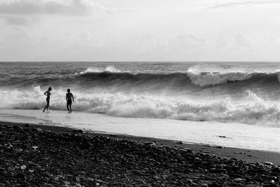 People on beach against sky