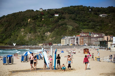 People at beach against sky