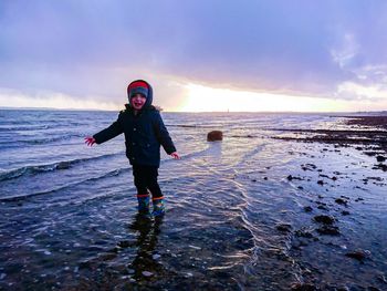 Full length of man standing on beach against sky