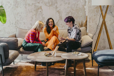 Cheerful business colleagues sitting on couch during event at convention center