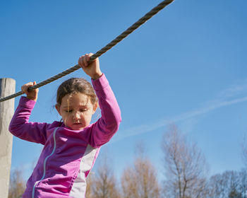 Girl on ropes and zip lines looks