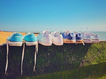 Deck chairs on beach against clear blue sky