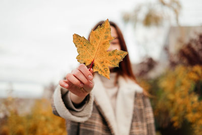 Cropped hand holding autumn leaf