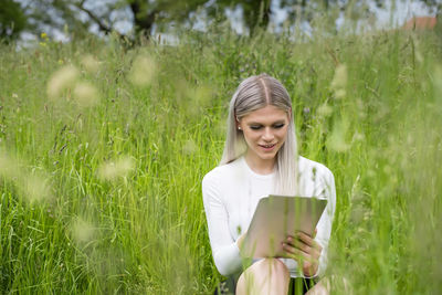 Young woman smiling while standing on field