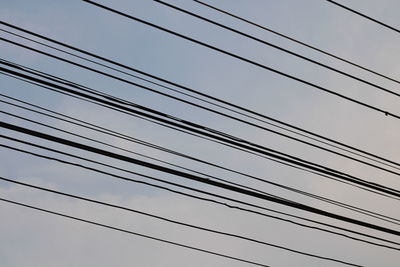 Low angle view of power cables against clear sky