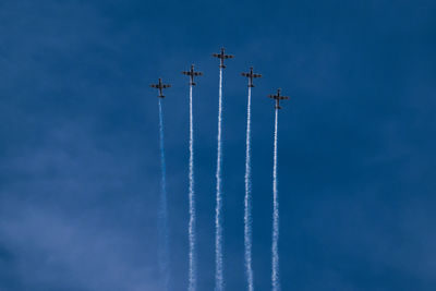 Low angle view of airplanes flying against sky