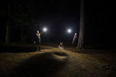 People standing on illuminated street at night