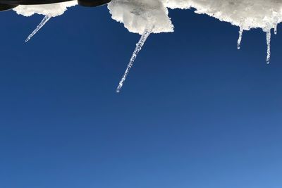 Low angle view of vapor trail against clear blue sky