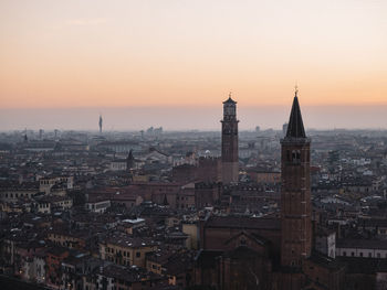 Aerial view of buildings in city at sunset