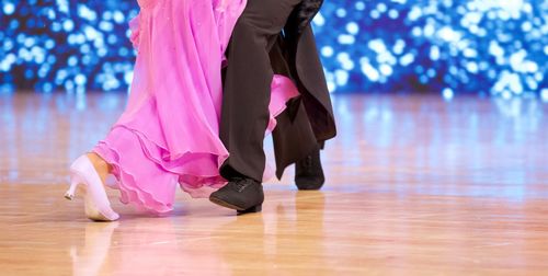 Low section of women standing on hardwood floor