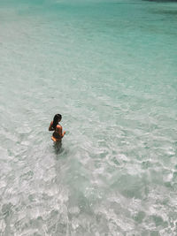 High angle view of woman standing in sea
