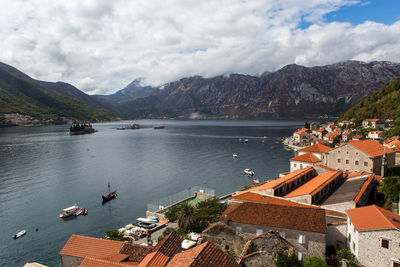 Roofs of old houses in perast and bay with mountains in montenegro