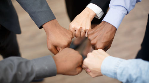 Midsection of business people stacking hands
