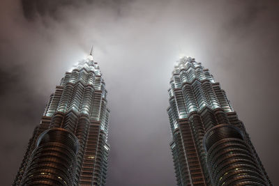 Low angle view of illuminated buildings against sky at night