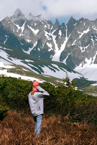 Rear view of man on snowcapped mountain