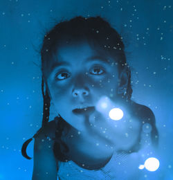 Girl with light in hands in a blue environment