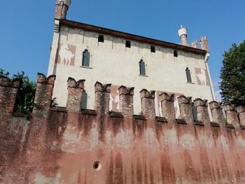 Low angle view of old building against clear blue sky