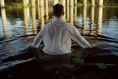 Rear view of man standing in lake