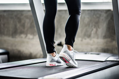 Low section of woman exercising on treadmill