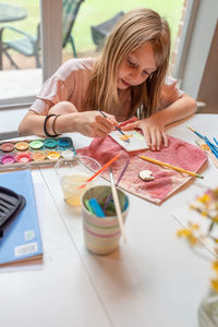 Full length of girl sitting on table