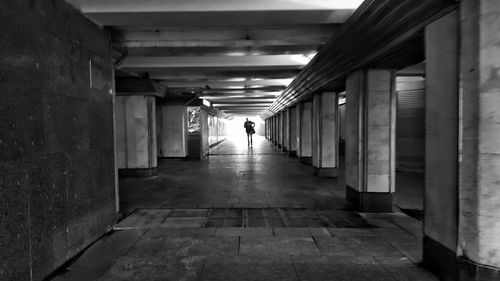 Rear view of man walking in corridor of building