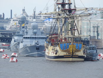 Sailboats moored at harbor