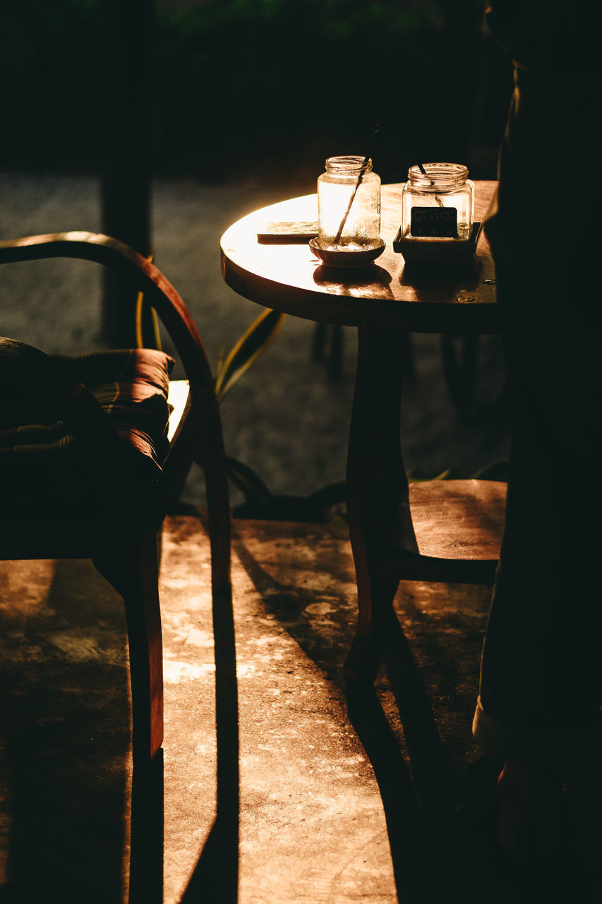 LOW SECTION OF PERSON STANDING ON TABLE AT HOME