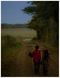 Rear view of women walking on road