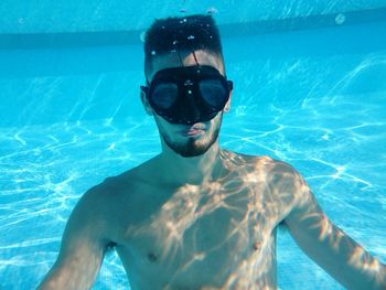 Shirtless man with goggle in swimming pool