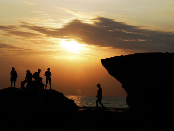 Silhouette people on beach during sunset