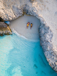 High angle view of people on rock in sea