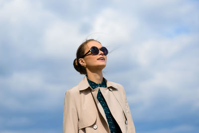 Portrait of young woman wearing sunglasses against sky