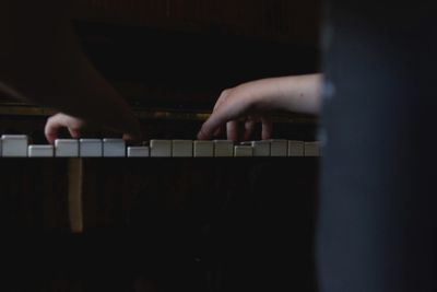 Cropped hands playing piano