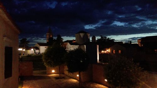 Illuminated buildings against sky at night