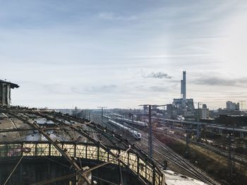 Railroad tracks in city against sky