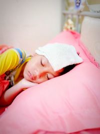 Girl suffering from fever while sleeping on bed at home