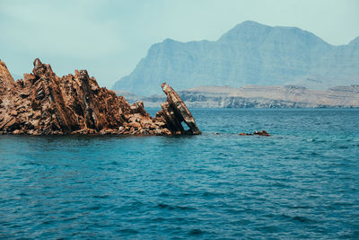 Scenic view of sea and mountains against sky