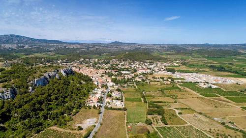 High angle view of agricultural field by buildings against sky