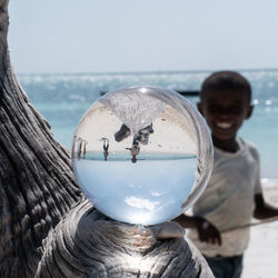 Portrait of smiling man in sea against sky