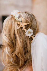 Rear view of woman with white flower