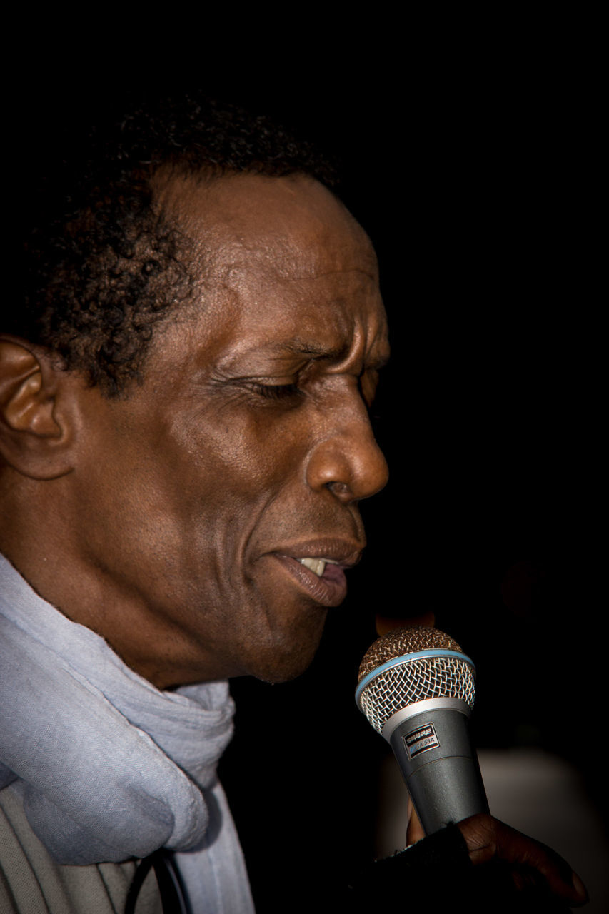 microphone, studio shot, black background, one person, holding, headshot, singing, men, close-up, night, one man only, indoors, musician, adult, people, adults only