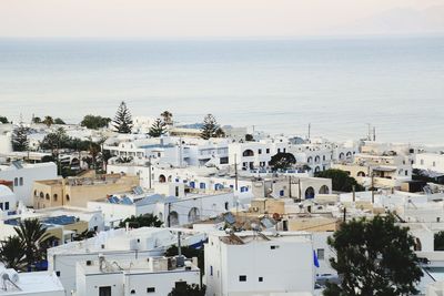 High angle view of townscape by sea against sky