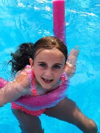High angle portrait of smiling girl swimming in pool