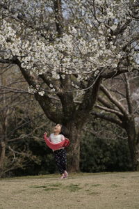 Full length of woman standing on tree