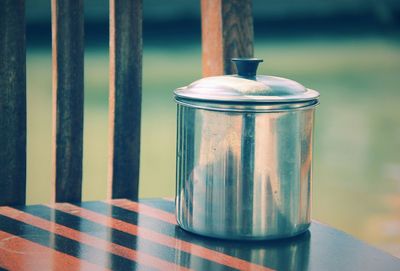 Close-up of container on wooden chair
