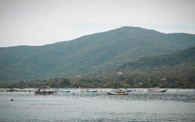 Scenic view of sea and mountains against sky