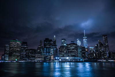 Illuminated buildings in city against sky at night