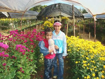 Full length of happy boy standing in greenhouse