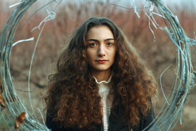 Portrait of young woman standing against plants