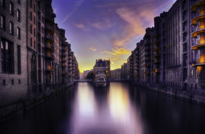 Buildings on canal at sunset